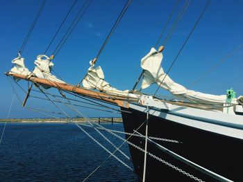 Sailboat sailing on sea against blue sky