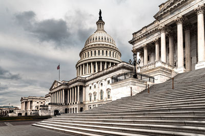 Facade of the united states capitol building in washington, d.c. on a cloudy and moody day. 