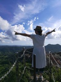 Rear view of person standing on landscape against sky