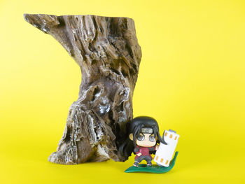 Close-up of statue against yellow background