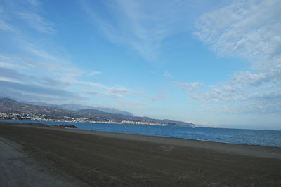 Scenic view of beach against cloudy sky