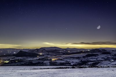 Scenic view of snowcapped mountains against sky at night