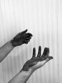 Cropped messy hands of man against wall