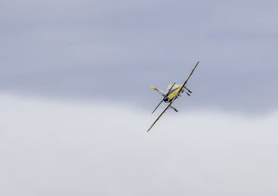 Low angle view of airplane flying against sky