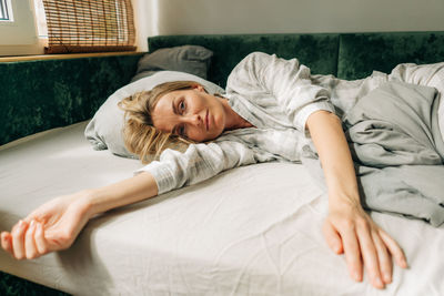 Young woman lying on bed at home