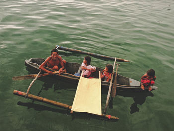 High angle view of people sitting on boat in lake