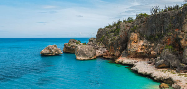 Scenic view of rocks in sea against sky