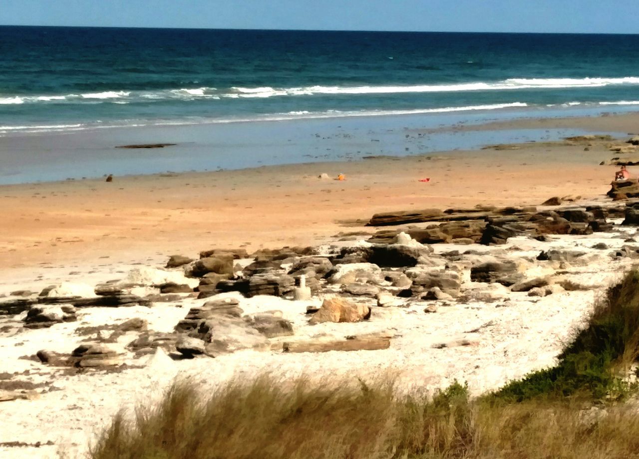 sea, beach, horizon over water, water, shore, sand, scenics, tranquil scene, tranquility, beauty in nature, wave, nature, rock - object, coastline, surf, sky, idyllic, rock formation, remote, incidental people