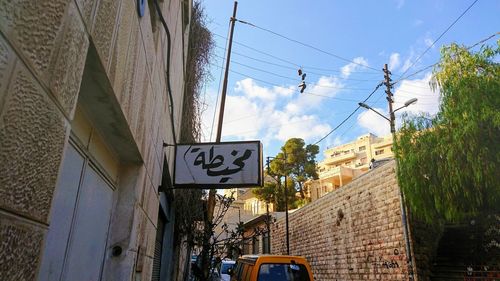 Low angle view of road sign against buildings in city