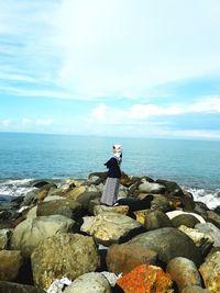 Woman standing at beach against sky