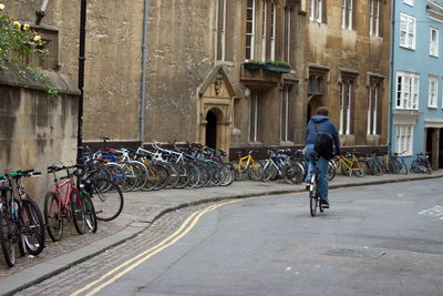 Rear view of man riding bicycle on road