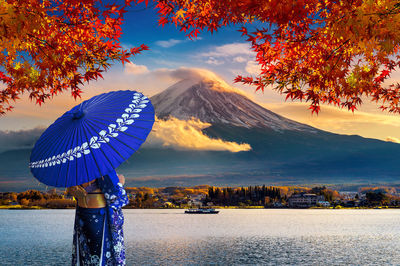 Scenic view of tree by mountain against sky during autumn