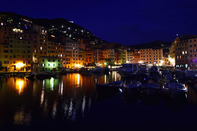 Boats moored in harbor at night