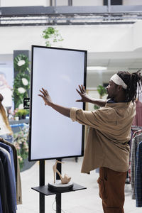 Side view of woman using digital tablet while standing in office