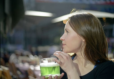 Young woman having drink outdoors