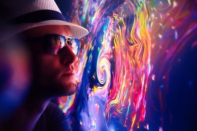 Portrait of man wearing multi colored light painting