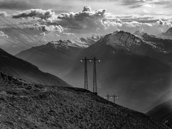 Electricity pylon against mountains