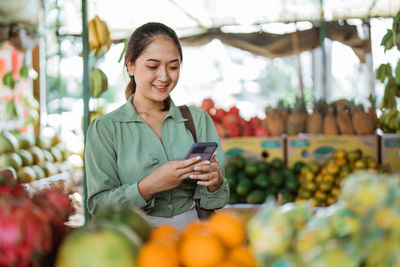 Young woman holding fruits in greenhouse