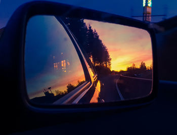 Reflection of sky on side-view mirror of car