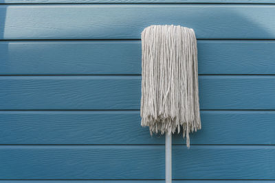 Close-up of mop against wooden wall