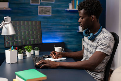 Side view of man using digital tablet while sitting at office