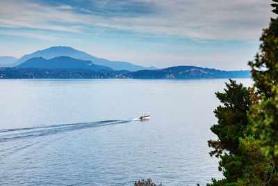 Scenic view of lake by mountains against sky