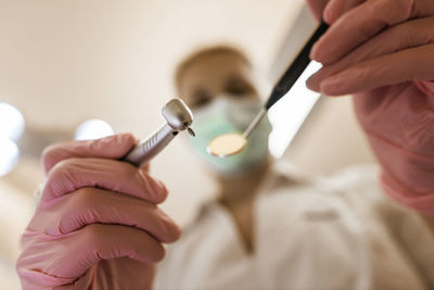 Dentist holding drill and mirror