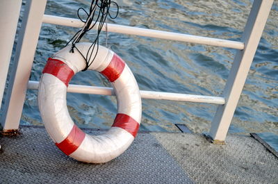 High angle view of ropes hanging on railing against sea