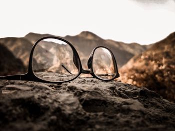 Close-up of sunglasses on rock