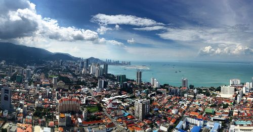 High angle view of cityscape by sea against sky