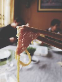 Close-up of hand holding ice cream on table