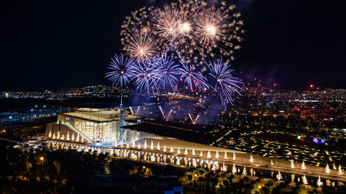 Firework display over city at night