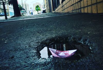 Close-up of paper boat on puddle