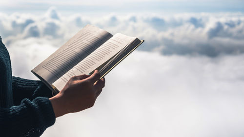 Midsection of person holding book