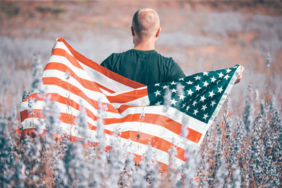 Rear view of man climbing flag