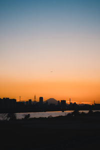 Silhouette of buildings against sky during sunset