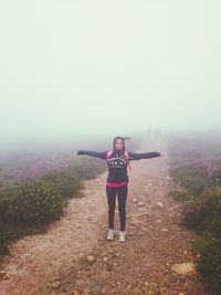 Woman standing in foggy weather