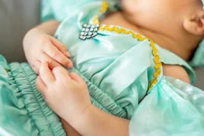 Close-up of baby girl lying on bed