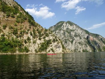 Scenic view of river and mountains against sky