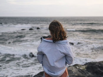 Rear view of woman looking at sea shore