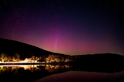 Scenic view of lake against sky at night