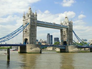 Bridge over river against cloudy sky