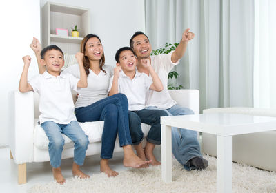 Happy family sitting on sofa at home