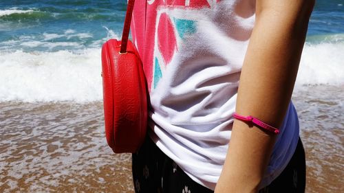 Midsection of woman standing on beach