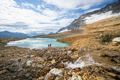 Two backpackers hiking along iceland trail near alpine lake in yoho