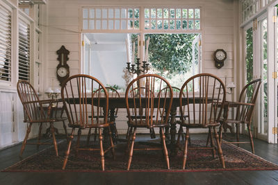 Empty chairs and table against building