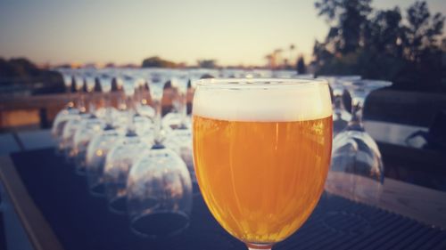 Close-up of beer in glass during sunset