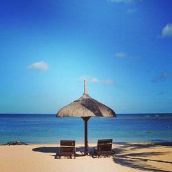Scenic view of beach against blue sky