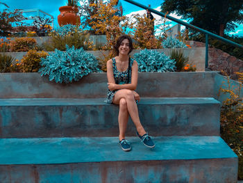 Portrait of woman sitting against built structure