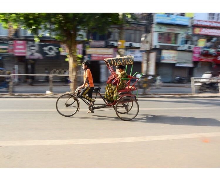 land vehicle, transportation, mode of transport, road, street, on the move, travel, built structure, car, architecture, building exterior, city, bicycle, motion, city life, men, city street, focus on foreground, roadside, parking, travel destinations, stationary, outdoors, person, day